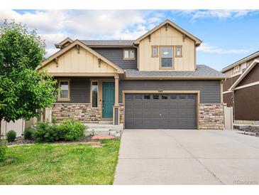 Beautiful two-story home with a teal front door and well-maintained landscaping at 1027 Auburn Dr, Erie, CO 80516