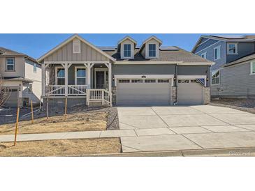 Charming two-story home with a two car garage, landscaped front yard, and covered front porch at 631 Sunrise St, Erie, CO 80516