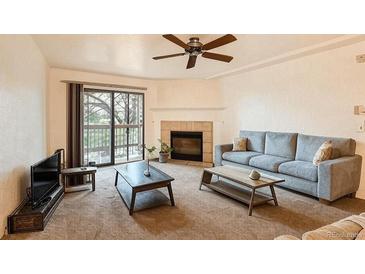 Comfortable living room featuring a fireplace, ceiling fan, and sliding glass door to the exterior at 10293 E Peakview Ave # F104, Englewood, CO 80111