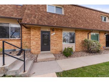 Charming brick townhome featuring a well-maintained walkway and front yard landscaping at 63 S Holman Way, Golden, CO 80401