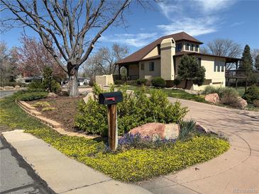 Charming home featuring a landscaped front yard, circular driveway, and a welcoming, covered porch at 2100 Robb St, Lakewood, CO 80215
