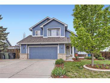 Charming two-story home featuring a well-maintained lawn, blue siding, and an attached two-car garage at 1663 E 96Th Pl, Thornton, CO 80229