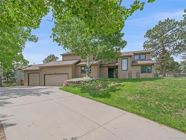 Inviting two-story home with a well-manicured lawn and a convenient two-car garage at 31412 N Bermuda Dunes Dr, Evergreen, CO 80439