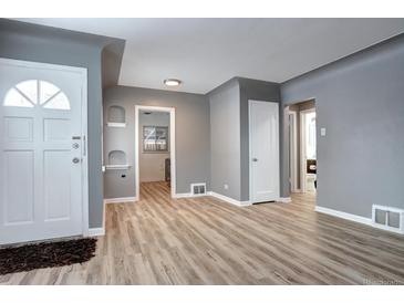 Inviting living room featuring sleek floors and white trim doors, offering a bright and modern aesthetic at 361 N Raleigh St, Denver, CO 80219