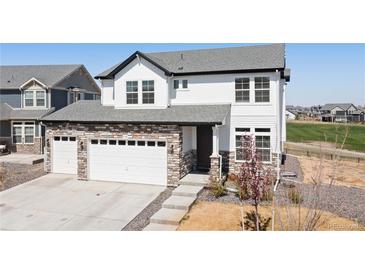 Charming two-story home with a stone and siding exterior and a two car attached garage at 11033 Olathe St, Commerce City, CO 80022