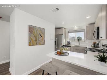 Modern kitchen features stainless appliances, breakfast bar, and stylish countertops at 8678 Decatur St # 283, Westminster, CO 80031