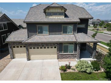 Beautiful two-story home featuring a three-car garage and a charming covered porch at 90 Pipit Lake Way, Erie, CO 80516