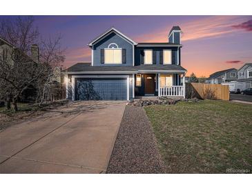 Charming two-story home with a blue exterior, well-manicured lawn, and a cozy front porch at 8653 Red Clover Ct, Parker, CO 80134