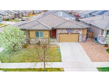Charming single-story home featuring a stone facade and well-maintained front yard with mature trees at 15484 E 115Th Ave, Commerce City, CO 80022