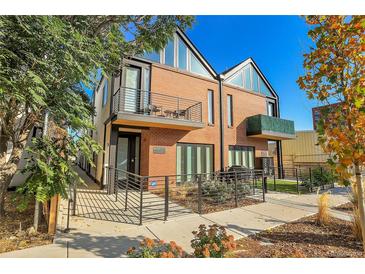 Contemporary townhome exterior with brick facade, balconies, modern railing and professional landscaping at 4232 Jason St # 7, Denver, CO 80211