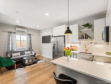 Open-concept living room flows to a modern kitchen, creating an inviting and stylish space at 4232 Jason St # 7, Denver, CO 80211