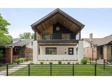 Stunning two-story home with modern design elements, including a balcony and manicured front lawn at 863 S Race St, Denver, CO 80209