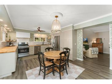 Charming eat-in kitchen with a round table, stainless steel appliances, and hardwood floors at 938 W Peakview Cir, Littleton, CO 80120
