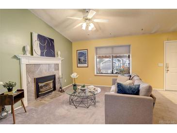 Bright living room with a cozy fireplace, plush seating, and ample natural light at 19326 E Greenwood Pl, Aurora, CO 80013