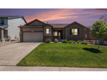 Charming brick home with a well-manicured lawn and professional landscaping at sunset at 2558 Northview Pl, Castle Rock, CO 80104
