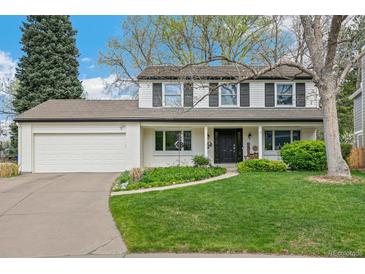 Charming two-story home with a well-manicured lawn, white exterior, black shutters, and an attached two-car garage at 6712 S Leyden Ct, Centennial, CO 80112