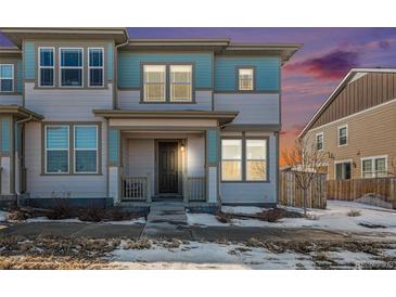 Two-story townhome with light blue and white siding, and a covered front porch at 14106 Red Cosmos St, Parker, CO 80134