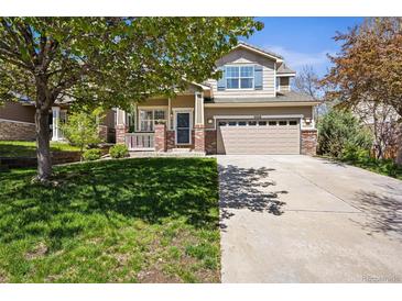 Charming two-story home with a two-car garage and a well-manicured lawn and front porch at 3928 Miners Candle Dr, Castle Rock, CO 80109