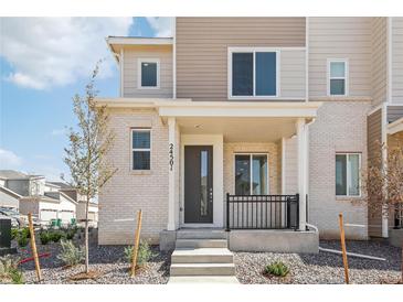 Modern two-story townhome with light brick exterior and covered porch at 24501 E 41St Ave, Aurora, CO 80019