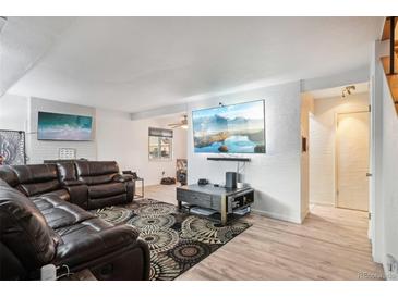 Spacious living room with large TV, leather sectional sofa, and decorative rug at 7995 E Mississippi Ave # J1, Denver, CO 80247