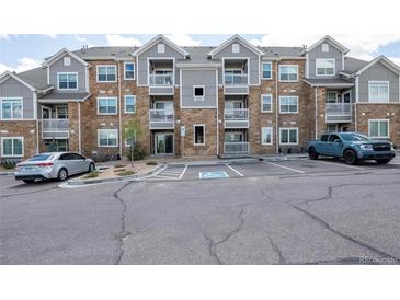 Attractive condo building with gray and stone facade, balconies, and convenient parking at 1881 S Dunkirk St # 106, Aurora, CO 80017