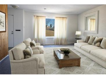 Bright living room featuring neutral decor, large windows, and comfortable seating at 8746 Mariposa St, Thornton, CO 80260