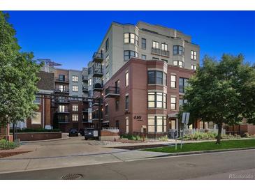 Beautiful brick building exterior with manicured landscape and mature trees at 410 Arizona Avenue at 410 Acoma St # 518, Denver, CO 80204