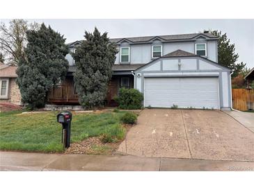 Charming two-story home featuring a front porch, attached two-car garage, and a well-maintained front yard at 15909 E Ford Pl, Aurora, CO 80017