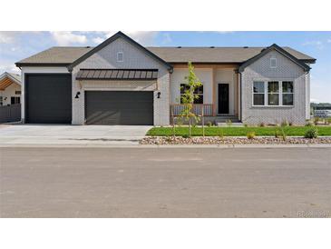 Charming single-story home featuring a brick facade, two-car garage, and a well-maintained front yard at 1425 Burt Ave, Berthoud, CO 80513