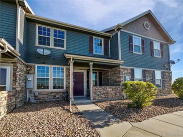 Attractive townhouse with stone accents, blue siding, and a covered front porch at 12713 Leyden St # E, Thornton, CO 80602