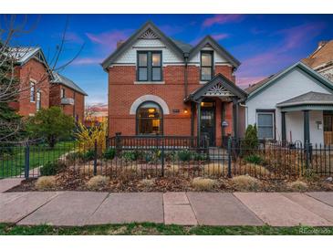 Charming brick home with a well-maintained front yard and inviting front porch at 2815 Curtis St, Denver, CO 80205