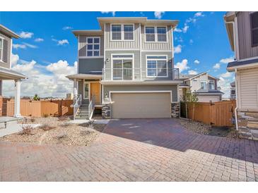 Inviting two-story home featuring a spacious two-car garage and charming exterior accents at 10124 Xanadu St, Commerce City, CO 80022
