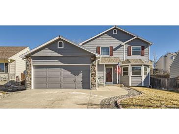 Charming two-story home with a gray exterior, stone accents, and a well-maintained front yard at 11042 Blackwolf Ln, Parker, CO 80138