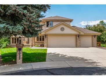 Two-story home with a three-car garage, brick accents, manicured lawn, and a large tree at 10227 Osceola Ct, Westminster, CO 80031