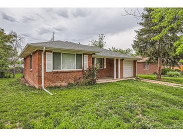Charming red brick home featuring a well-manicured lawn and an attached one car garage at 1325 Geneva St, Aurora, CO 80010