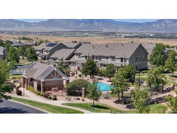 Community pool surrounded by townhomes and beautiful mountain views on the horizon at 4718 Raven Run, Broomfield, CO 80023