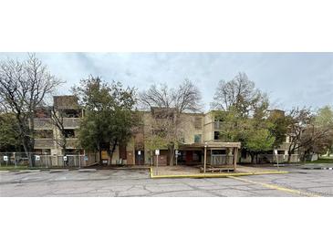 A multi-story apartment complex featuring mature trees and a covered entrance at 1302 S Parker Rd # 316, Denver, CO 80231