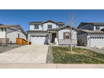 Charming two-story home with a two-car garage, well-kept lawn, and stone veneer accents at 6646 Merrimack Dr, Castle Pines, CO 80108