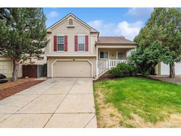 Two-story home featuring a well-kept lawn, an attached two-car garage, and mature landscaping at 21052 E 45Th Ave, Denver, CO 80249