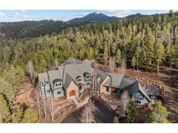 Stunning home nestled in the trees with stone accents and beautiful roof design at 11406 Conifer Ridge Dr, Conifer, CO 80433