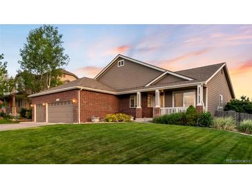 Charming two-story home with a well-manicured lawn, brick accents, a covered porch and attached two car garage at 1758 Parkdale N Cir, Erie, CO 80516