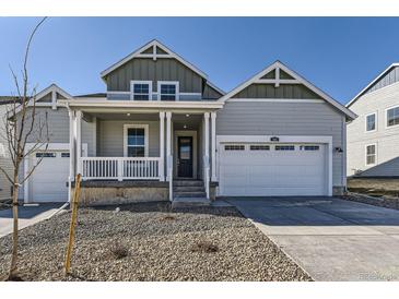 Charming gray two-story home featuring a covered porch, white trim, and a two-car garage at 968 Congress Pl, Elizabeth, CO 80107