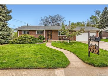 Charming brick home featuring a well-manicured lawn, curved walkway, and mature landscaping at 798 Alkire St, Lakewood, CO 80401