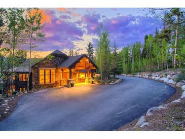Stunning exterior view of the stone home, showing a winding drive and manicured landscaping at 41 Stillson Placer Ter, Breckenridge, CO 80424