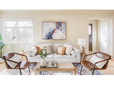 Cozy living room featuring a stylish sofa, elegant decor, and abundant natural light, perfect for relaxation at 4215 W Byron Pl, Denver, CO 80212