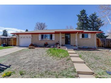 Charming single-story home featuring a red-bricked facade, a well-manicured lawn, and an attached one-car garage at 8221 Ralph Ln, Denver, CO 80221