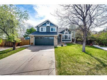 Charming two-story home featuring a well-manicured lawn, a two-car garage, and tasteful landscaping at 18572 E Tanforan Pl, Aurora, CO 80015