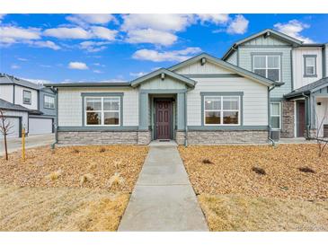 Charming home showcasing great curb appeal with stone accents and manicured landscaping at 152 Ambrose St, Erie, CO 80516