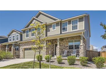 Charming two-story home with stone accents, a covered porch, and beautifully landscaped front yard at 417 S Ouray St, Aurora, CO 80017