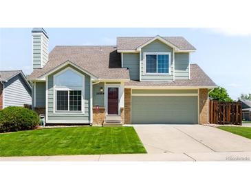 Inviting two-story home with a well-manicured lawn, attached two car garage, and charming curb appeal at 20389 E Powers Pl, Centennial, CO 80015